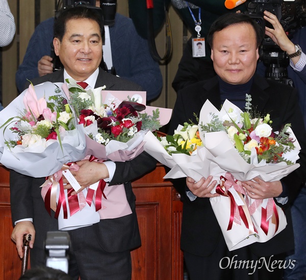자유한국당 새 원내대표와 정책위의장으로 선출된 심재철, 김재원 의원이 지난 9일 국회에서 열린 의원총회에서 꽃다발을 받아들고 있다. 