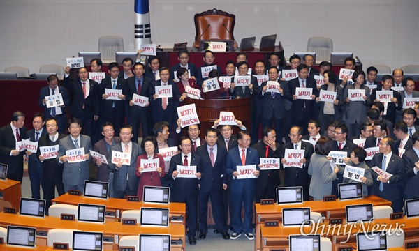 10일 오후 국회 본회의에서 한국당 뺀 '4+1' 예산 수정안이 통과된 후 자유한국당 심재철 원내대표를 비롯한 의원들이 의장석으로 나와 항의하며 피켓을 들어보이고 있다. 