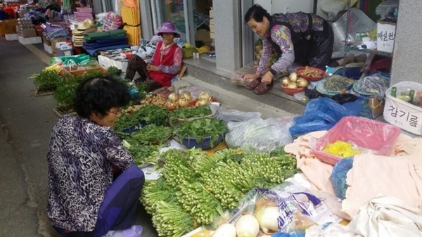 시골장날 할머니들이 야채를 팔고 있다.