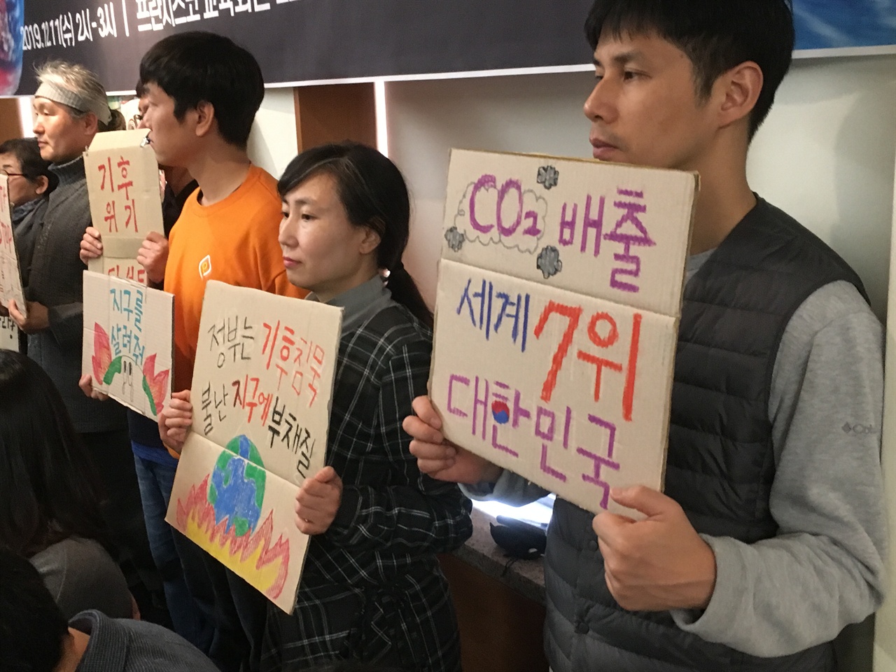 기후위기 비상행동에 참석한 환경단체 회원이 세계 탄소배출량 7위를 기록한 정부를 비판하는 피켓을 들고 있다.