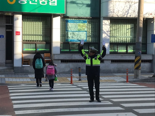 김학봉씨가 아침 일찍부터 홍천초교 후문에서 교통 수신호를 하고 있다.