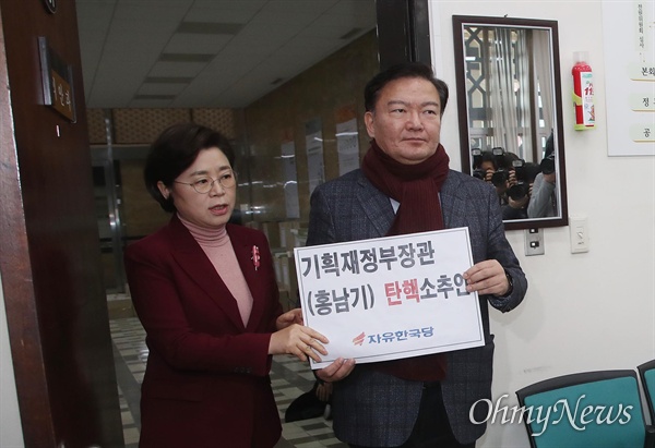 자유한국당 민경욱 원내부대표와 김정재 원내대변인이 12일 오후 서울 여의도 국회 의안과에서 홍남기 부총리 겸 기획재정부 장관에 대한 탄핵소추안을 제출하고 있다.