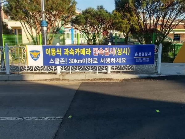 학교 앞 도로에 '이동식 과속 카메라 단속실시(상시)', '스쿨존, 30km 서행' 펼침막을 설치했다.