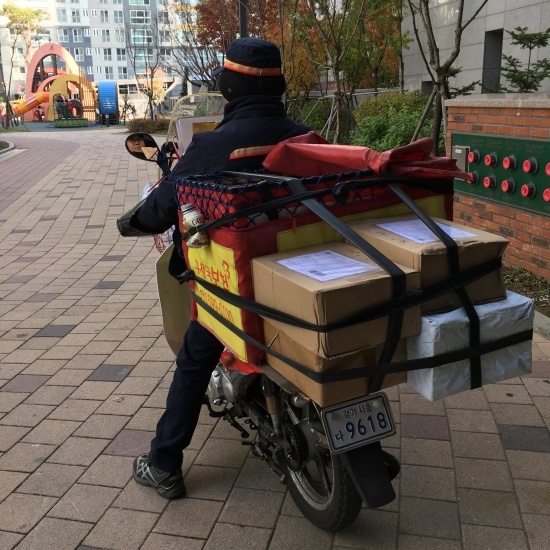 시흥우체국 집배원 최승묵 씨가 오토바이에 우편물을 가득 싣고 아파트 단지로 들어서고 있다. 
