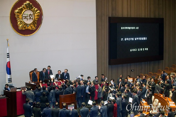 문희상 국회의장이 2019년 12월 23일 오후 서울 여의도 국회 본회의에서 의사 일정을 변경 동의를 통해 패스트트랙(신속처리안건 지정) 선거법 개정안을 상정하자, 자유한국당 의원이 단상에 나와 항의하고 있다.