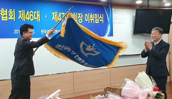 정규성 회장이 김동훈 신임 회장에게 기자협회 깃발을 인계했다.