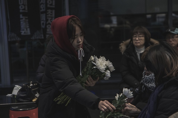 우동민열사 영정사진에 헌화를 하기 위해 국화꽃을 나눠주고 있다.