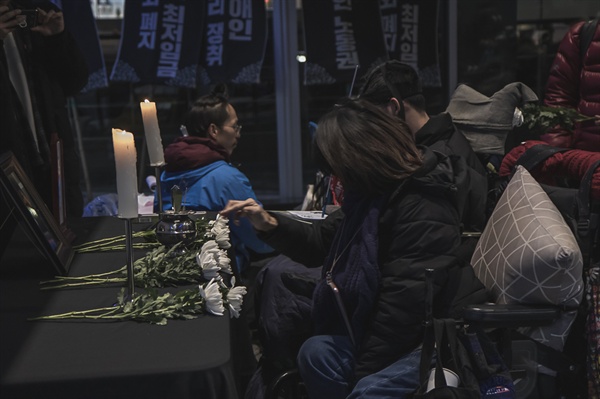 우동민열사 영정사진에 동료활동가가 꽃을 헌화하고 있다. 