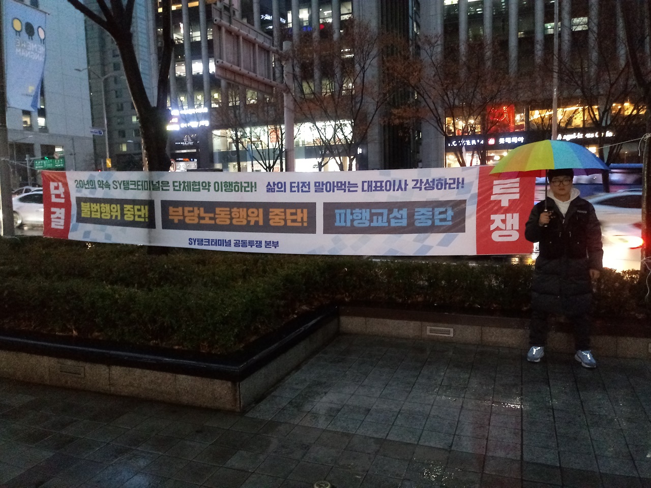 비오는 7일 저녁, 박영석 공동집행위원장(에스와이탱크터미널지회 사무장)이 에스와이탱크터미널 본사 앞에서 1인시위를 하고 있다.