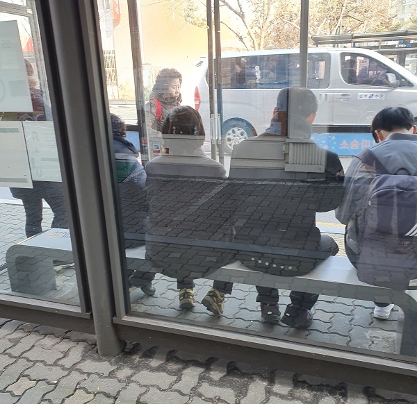 온열의자에 앉아 버스를 기다리고 있는 주민들. 
