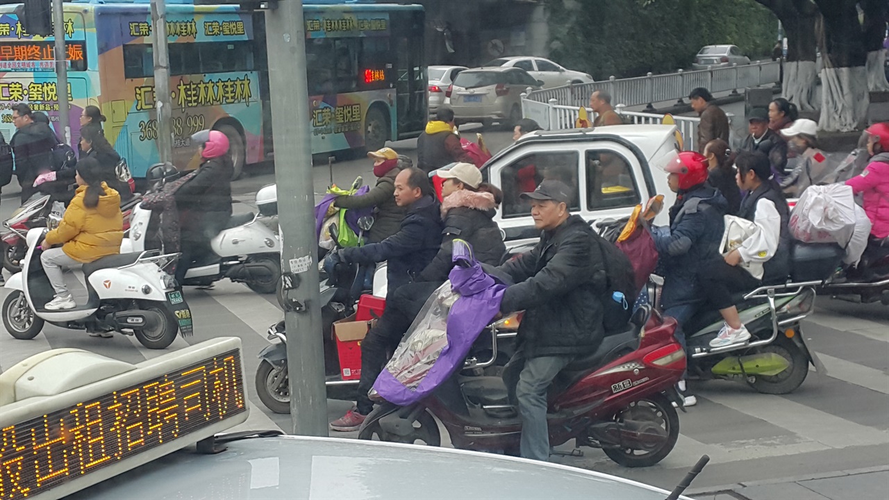 밧데리 오토바이, 소형차들을 타고 출근하는 모습