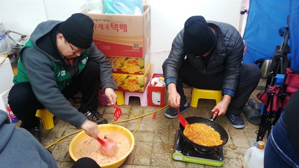 김치 부침개를 부치고 있는 요금수납 노동자들