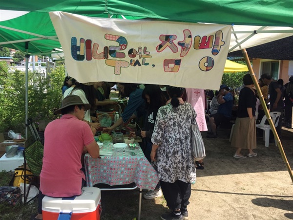 살래장 부스에 달아놓은 ‘비니루 없는 점빵’ 현수막. 마을 친구들이 조각천을 이어붙여 만들었다. 