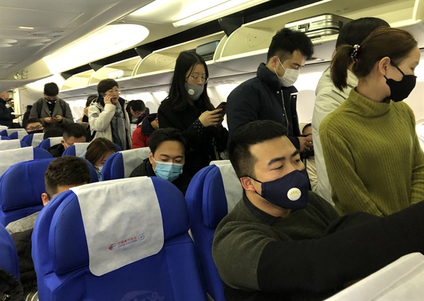 21일 중국 상하이를 출발해 우한으로 향하는 항공기에 탄 승객들이 신종 코로나바이러스 감염을 막고자 마스크를 쓰고 있다.