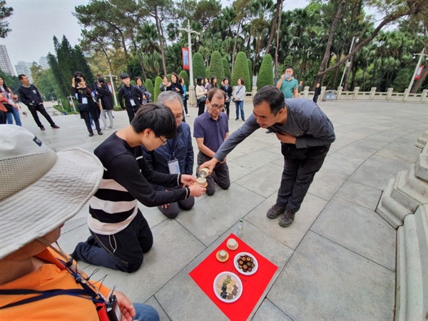 기의열사능원 합동묘역 앞에서 한국에서 준비해 온 막걸리를 올리는 청년백범 답사단