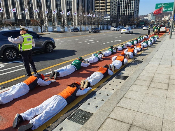 고속도로 요금수납원들이 '직접고용'을 요구하며 서울 광화문 거리에서 오체투지를 하고 있다.