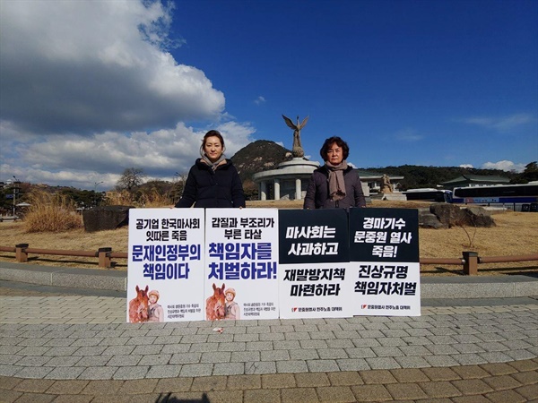  한국마사회 부산경남경마공원 고 문중원 기수의 어머니와 누나가 30일 청와대 분수대 앞에서 '고인의 죽음에 대한 진상규명과 책임자 처벌'을 정부에 촉구하는 손팻말을 들고 서 있었다.