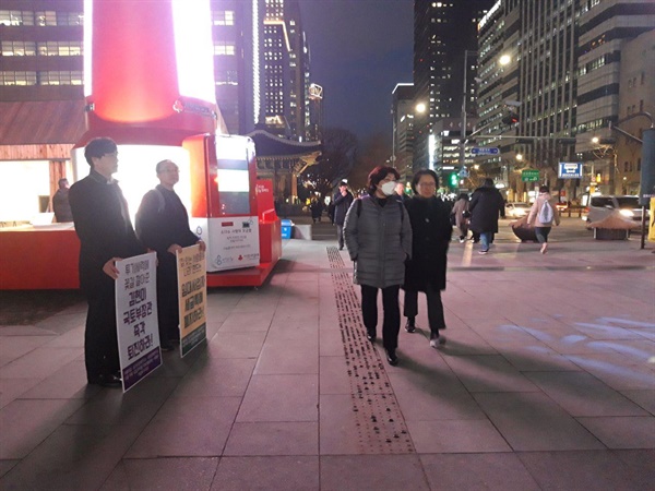 1월 29일 서울 도심에서 피켓을 들고 서 있는 시민들의 모습