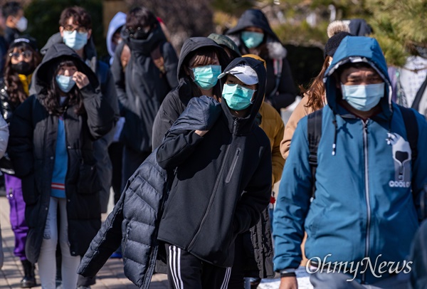 코로나19 전염을 막기 위해 마스크를 쓰고 거리를 지나는 시민들.