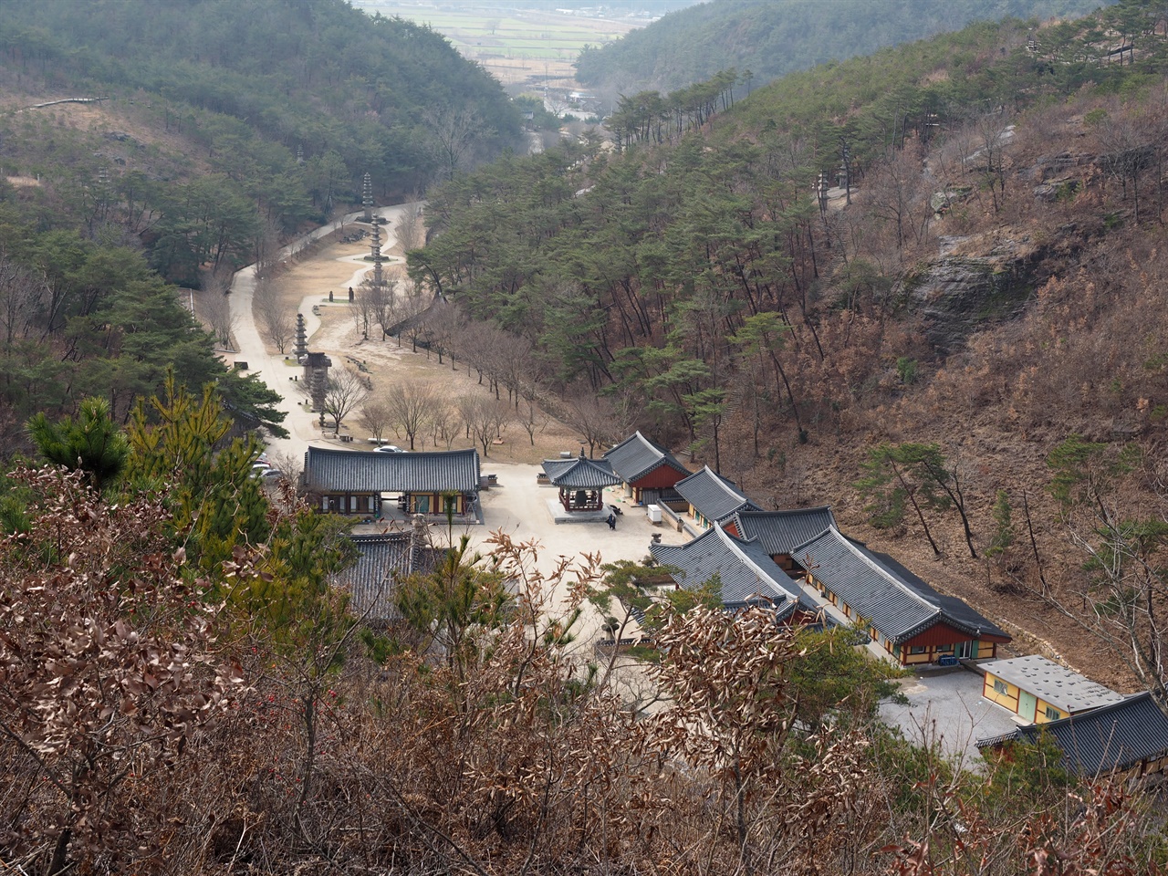 불사바위에서 본 운주사 전경 남북으로 길게 이어진 골짜기와 능선을 따라 탑과 불상이 배치되어 있다. 사진 우측 상단부에 와불이 보인다.