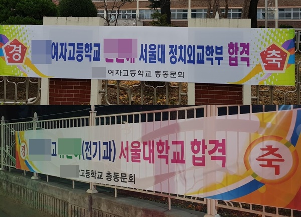 고등학교 동문회 이름으로 학교 담벼락과 거리에 "서울대 합격 축하" 플래카드가 걸려 있다.