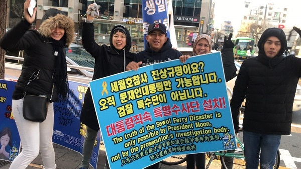 홍대집중행동 중 외국인들에게 세월호참사 진상규명을 설명하고 함께 활동하고 있는 모습.  .