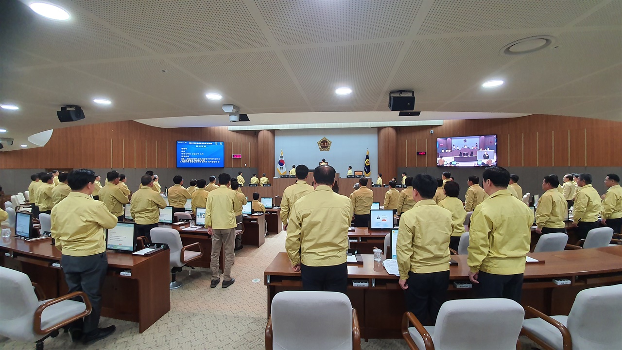 충남도의회 의원들이 본회의장에서 국기에 대한 경례를 하고 있다.