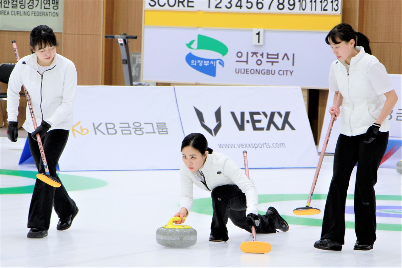  코리아 컬링 리그 경기에서 전북도청 정재이 선수(가운데)가 스톤을 투구하고 있다. 김지현(왼쪽), 신가영 선수가 스윕을 위해 달려가고 있다.