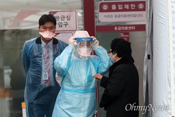 13일 오후 서울 구로구 고려대학교구로병원 응급실 앞에서 의료진이 코로나19(신종 코로나바이러스 감염증) 예방을 위해 내원객들의 발열을 체크하고 있다.