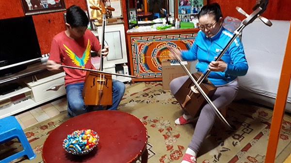 몽골 수도인 울란바타르 게르에서 마두금을 연주하는 여성과 소년 모습. 여성은 음악교사이다.