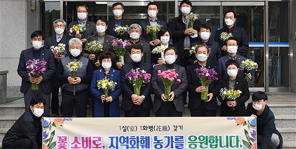 강릉시의회 의원들이 '1인1화병 갖기' 캠페인을 시작하며 지역 화훼농가에서 구입한 꽃을 들고 기념촬영을 하고있다.