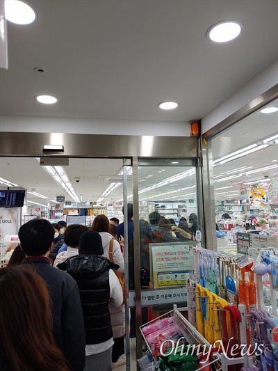24일 오전 서울 영등포구 여의도 인근 상점에 마스크를 사려는 사람들이 길게 줄을 서있다.