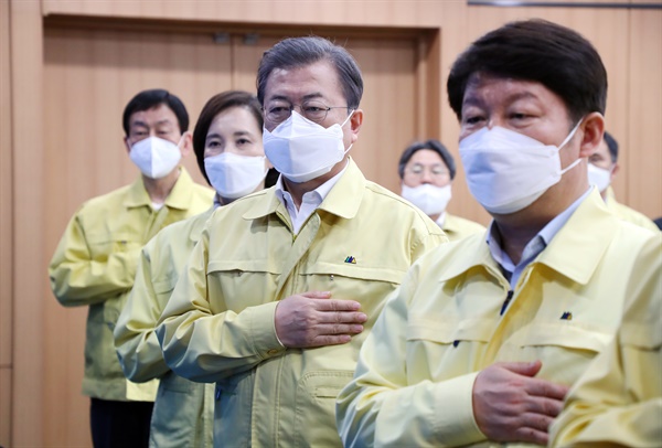 문재인 대통령이 25일 대구시청에서 열린 신종 코로나바이러스 감염증(코로나19) 대구지역 특별대책회의에서 국기에 경례하고 있다.