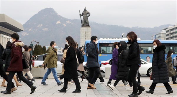 24일 서울 광화문역 사거리 횡단보도에서 시민들이 코로나 19 예방 등의 이유로 마스크를 착용하고 출근하고 있다. 