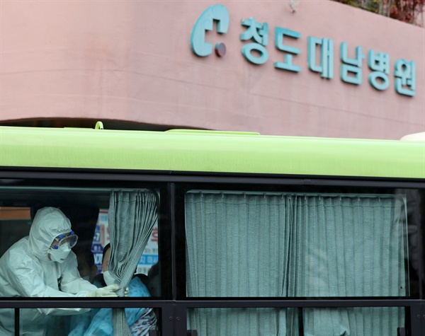 지난 2월 27일 오후 경북 청도대남병원에서 서울 국립정신건강센터로 이동하는 환자 이송 버스 안에서 한 의료진이 커튼을 치고 있다.