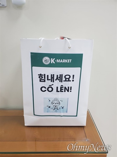하노이에 격리된 한국인들에게 전달할, K-Market에서 준비한 물품 쇼핑백. 이 안에는 컵라면 3개, 김치(500g) 1개, 손소독제(대용량) 1개, 물 500ml 1개, 물티슈 1개, 고추장 1개, 스낵(간식용) 2개가 들어있다.