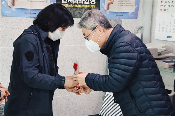 노회찬재단 관계자들이 세계여성의날을 맞아 5일 국회 청소노동자들에게 장미꽃을 전달하고 있다.