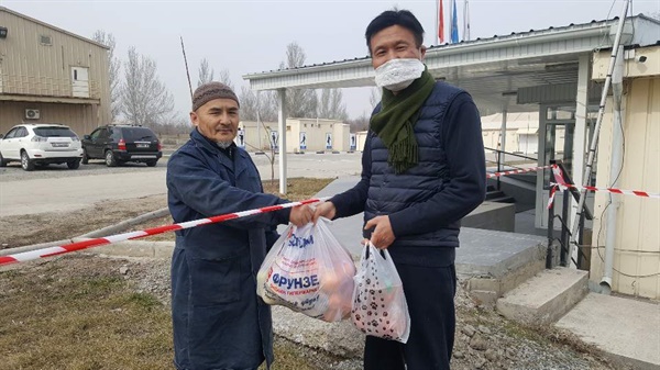 한인 격리박사 바로 옆 키르기즈 관세국 직원 에밀이 한인들이 격리된 막사를 찾아 과일보따리를 건네고 있다