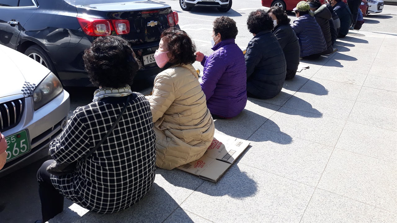 공주시 옥룡동 소재의 농협하나로마트 앞에 번호표를 든 공적 마스크 구매 희망자들이 앉아 있다.