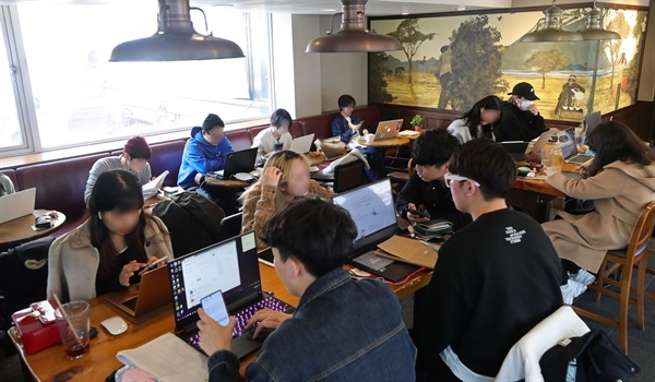신종코로나바이러스 감염증(코로나19) 확산 예방을 위해 서울 주요대학이 온라인 강의를 실시한 지 이틀 째인 17일 오후 서울 마포구 홍익대학교 인근 한 카페에서 대학생 및 시민들이 시간을 보내고 있다.
