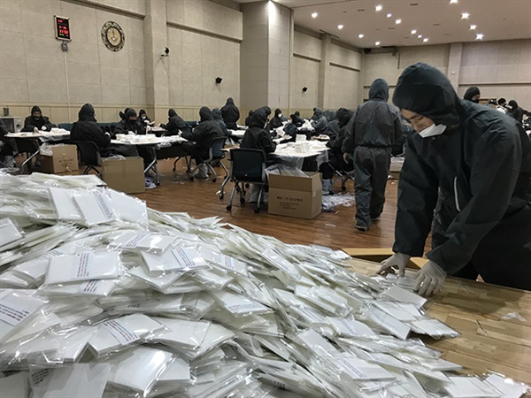 강릉시청 공무원들이 근무시간이 끝난 뒤 강릉시민 모두에게 '필터 교체형 마스크'를 무상공급하기 위한 필터와 포장 작업으로 땀 흘리고 있다.