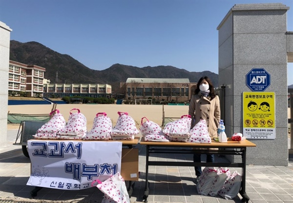  창원 신월중학교가 교과서를 정문 앞에서 '승차형 전달'하고 있다.