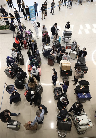 유럽에서 국내로 들어오는 입국자에 대한 검역 절차가 강화된 22일 오후 인천국제공항 2터미널에서 영국 런던에서 여객기를 타고 입국한 승객들이 진단 검사를 받는 곳으로 이동하기 위해 대기하고 있다. 2020.3.22