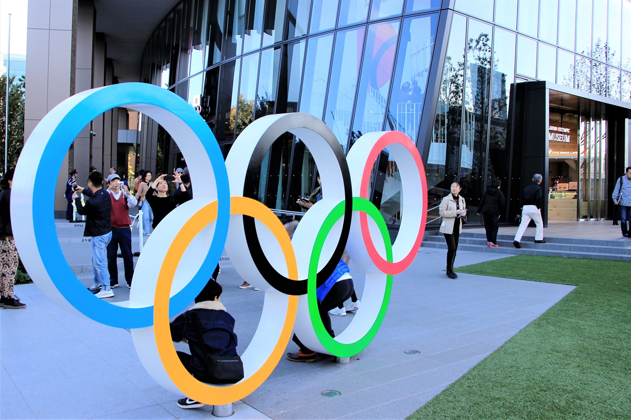  도쿄 가스미가오카에 위치한 일본 올림픽 박물관 앞에 전시된 오륜 마크 앞에서 일본 시민들이 사진을 촬영하고 있다. 2020년 7월로 예정된 도쿄 올림픽은 코로나19로 인해 연기된 상황이다.