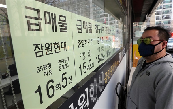  지난 24일 서울 서초구 한 공인중개사 앞에서 시민이 급매 게시물을 살펴보고 있다.