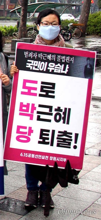 6.15창원지부 회원이 '도로 박근혜당 퇴출'이라고 쓴 손팻말을 들고 창원 정우상가 앞에 서 있다.