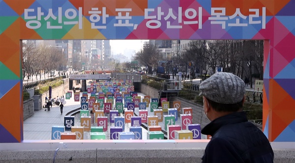 30일 오전 서울 중구 무교동 청계천 모전교에서 한 시민이 21대 총선 '4.15 아름다운 선거' 홍보 조형물을 바라보고 있다. 