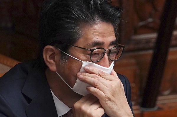  아베 신조 일본 총리가 지난 3일 참의원 본회의에 참석, 쓰고 있던 마스크를 조절하고 있다. 일본의 신종 코로나바이러스 감염증(코로나19) 확진자 수는 전날 하루에만 241명 늘어나는 등 연일 급증세를 보이고 있다.