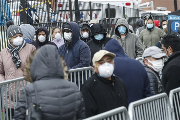 지난 3월 25일(현지시간) 미국 뉴욕 퀸스의 엘름허스트 병원 입구에서 시민들이 마스크를 쓴 채 신종 코로나바이러스 감염증(코로나19) 검사를 받기 위해 줄을 서서 차례를 기다리고 있다.