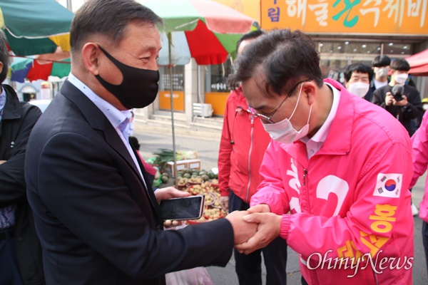 지난 6일 대구 달서구 이곡동 월요시장에서 홍석준 미래통합당 후보가 유권자들을 만나 손을 잡고 인사를 하고 있는 모습.